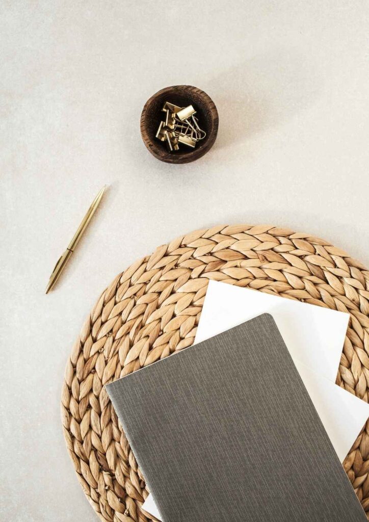 Notebook and pen on woven placemat — representing clarity, planning, and organisation with Ikigai Wealth.