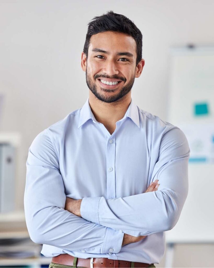 Confident man smiling with arms crossed, representing approachable, trustworthy financial guidance from Ikigai Wealth.