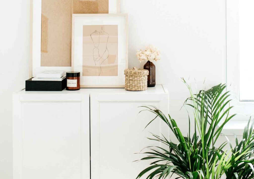 Bright minimal interior with framed art and plant, representing calm, structure, and financial freedom.