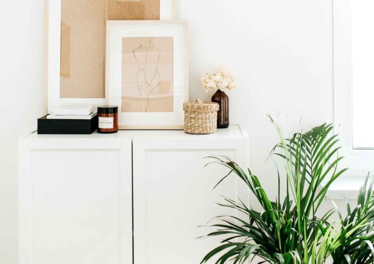 Bright minimal interior with framed art and plant, representing calm, structure, and financial freedom.