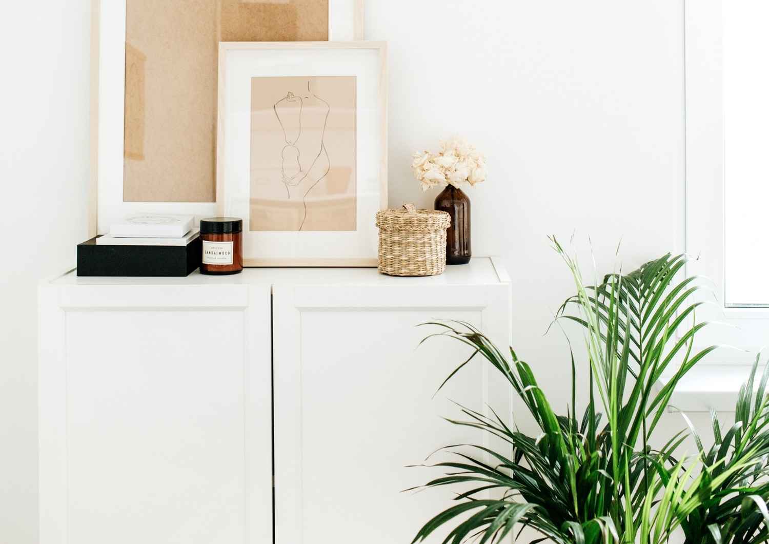 Bright minimal interior with framed art and plant, representing calm, structure, and financial freedom.